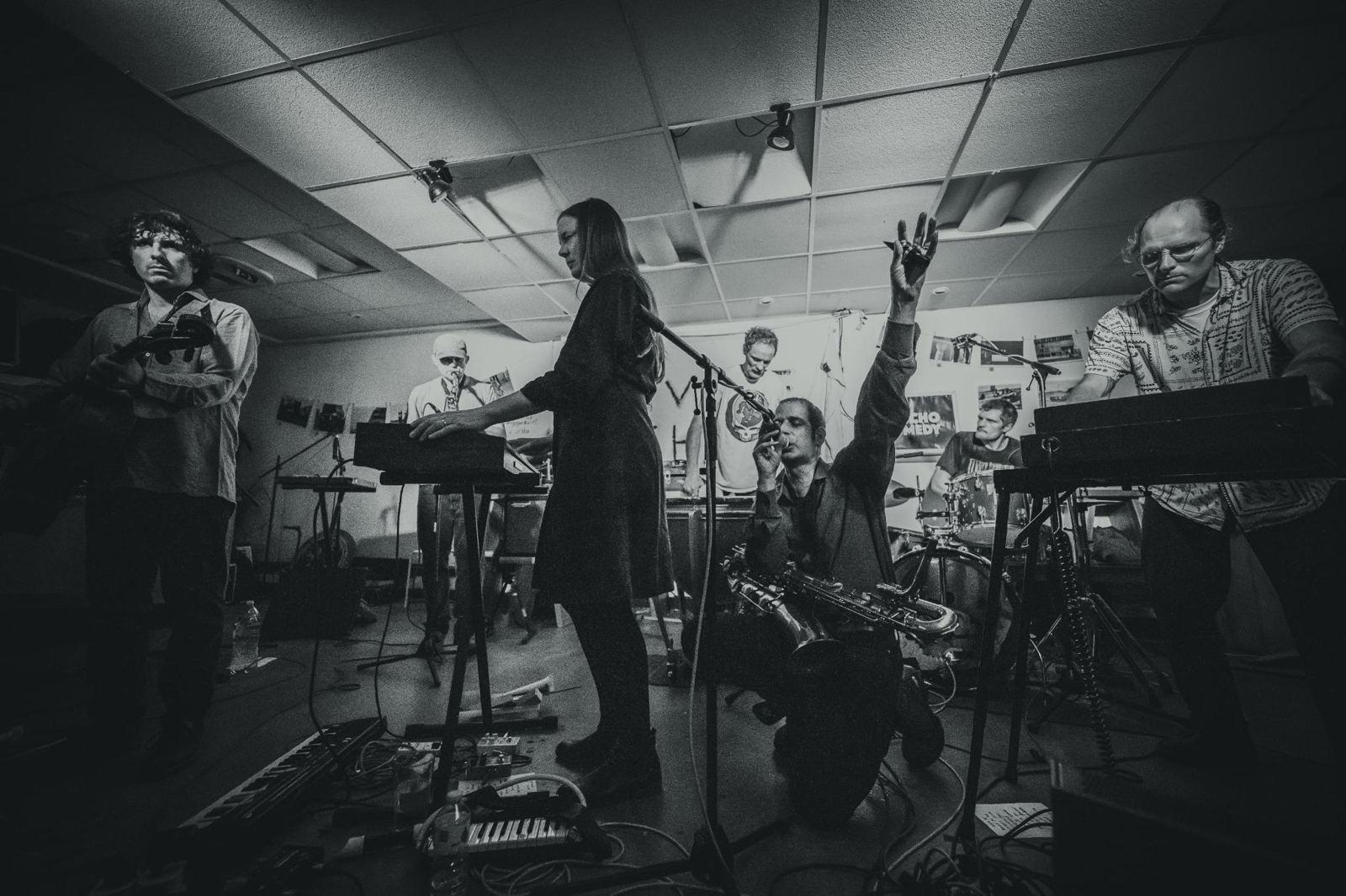Kulku live: acht Musiker mit Keyboards, Saxophon, Schlagzeug und Pauke in einem kleinen Raum